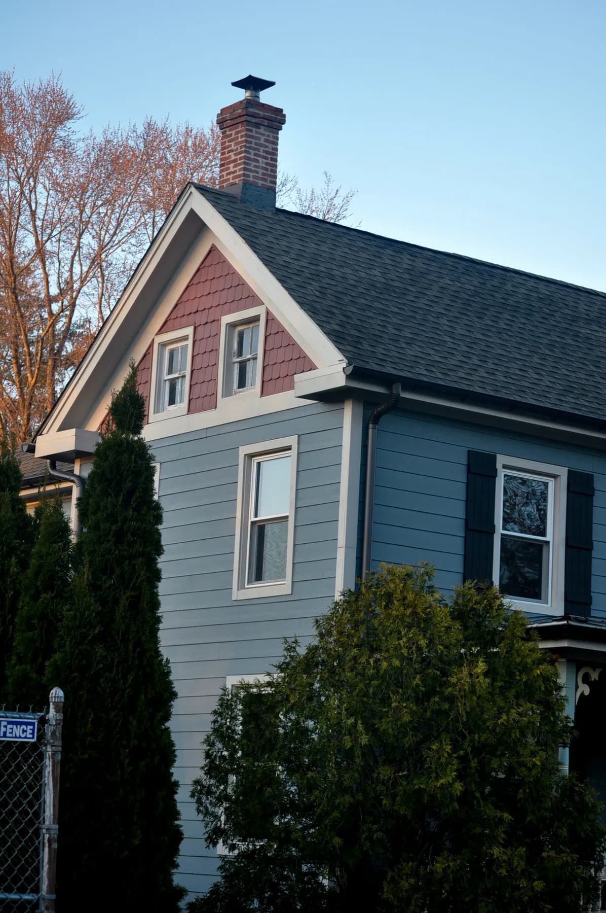 Gable end of the same house, new shingles running up to a brick chimney