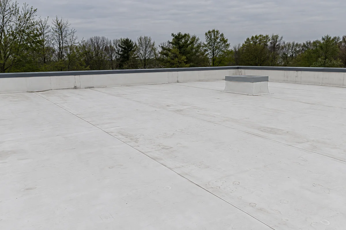 AI-generated illustration: A broad off-white membrane roof with seams and a parapet.